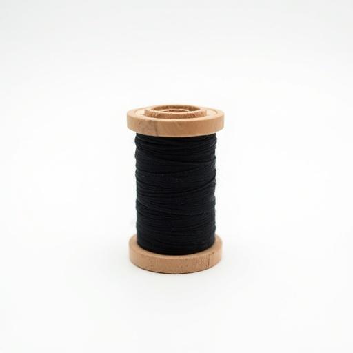 Realistic photo of black thread on wooden spool. Neatly wound and placed vertically. White background ensures focus. Soft studio lighting offers modern aesthetic.