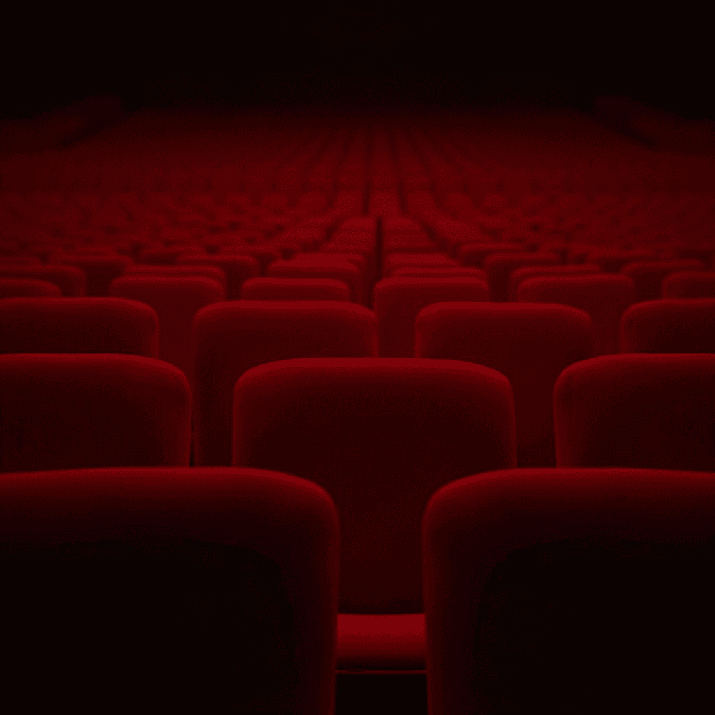 An empty theatre with red velvet seats fading into darkness.