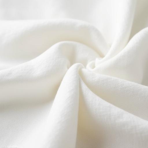 Close-up of soft cotton fabric texture showcasing fine weave and natural fibers with a clean white background. High-resolution studio shot emphasizing the fabric's softness.