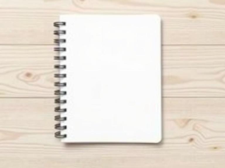 Blank notebook with spiral binding on light wood background. Slightly tilted top view. Rounded corners. Minimalistic style.