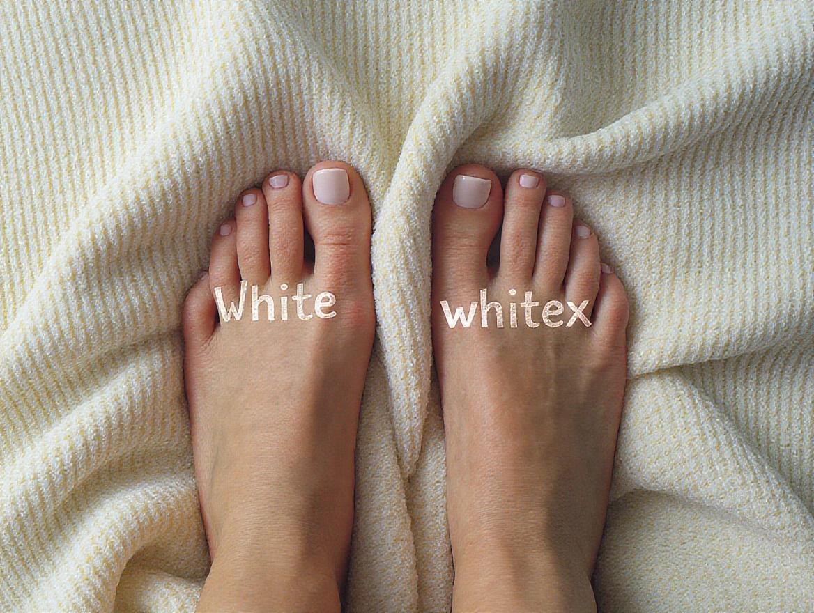 Perfect women's feet with white nail polish on a textured blanket.