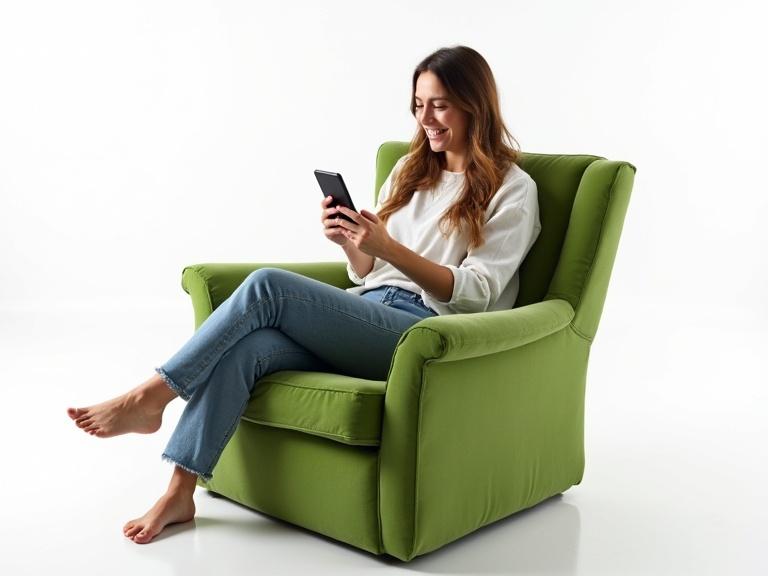 Woman sitting on a green armchair. Using smartphone and smiling. White background.