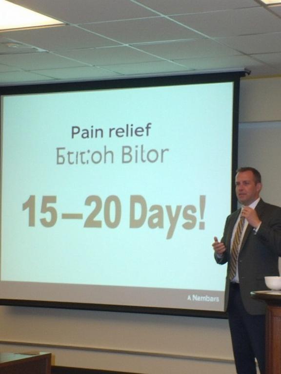 Presentation slide highlighting pain relief in a specific duration. Speaker gestures while emphasizing the message.
