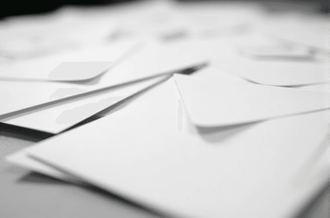 A close-up image of several white envelopes scattered randomly across a surface.