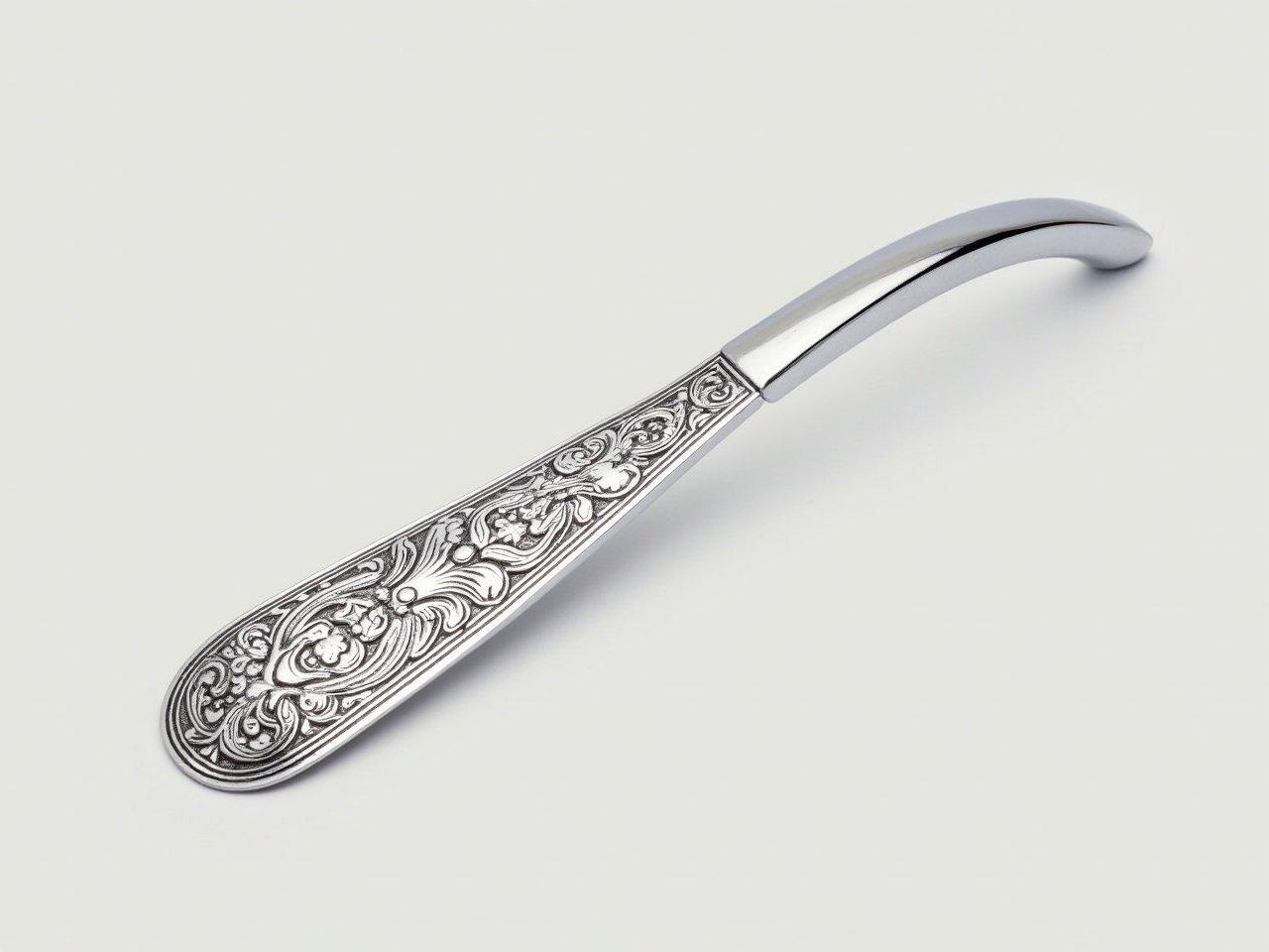 This image features a beautifully designed metal shoehorn. The shoehorn has an intricate pattern engraved on its surface, showcasing detailed floral and decorative elements. Its elongated and slim shape allows for easy handling and usage. The design combines both functionality and elegance, making it a suitable accessory for one’s wardrobe. The shiny metal finish adds to its aesthetic appeal, catching the light beautifully. The overall look and feel of the shoehorn suggest it could be a special or gift item.