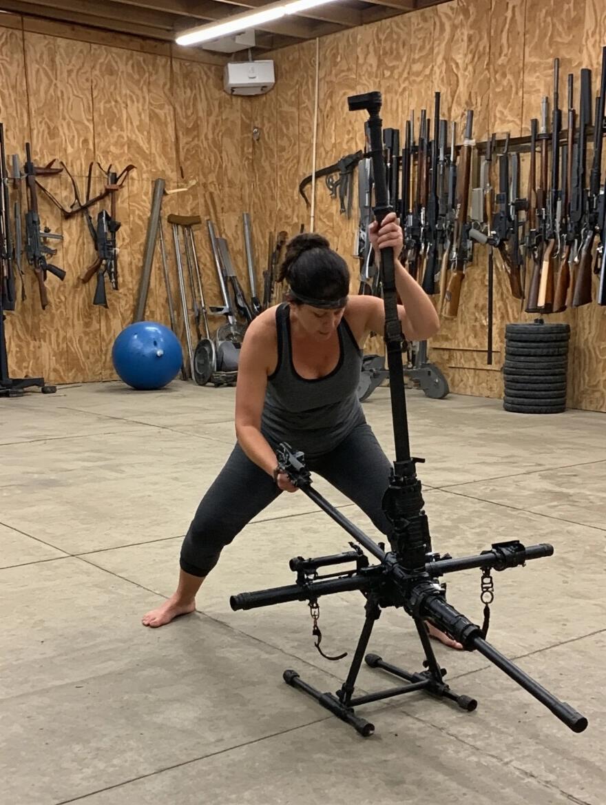 Woman barefoot training weapon handling in an indoor gym