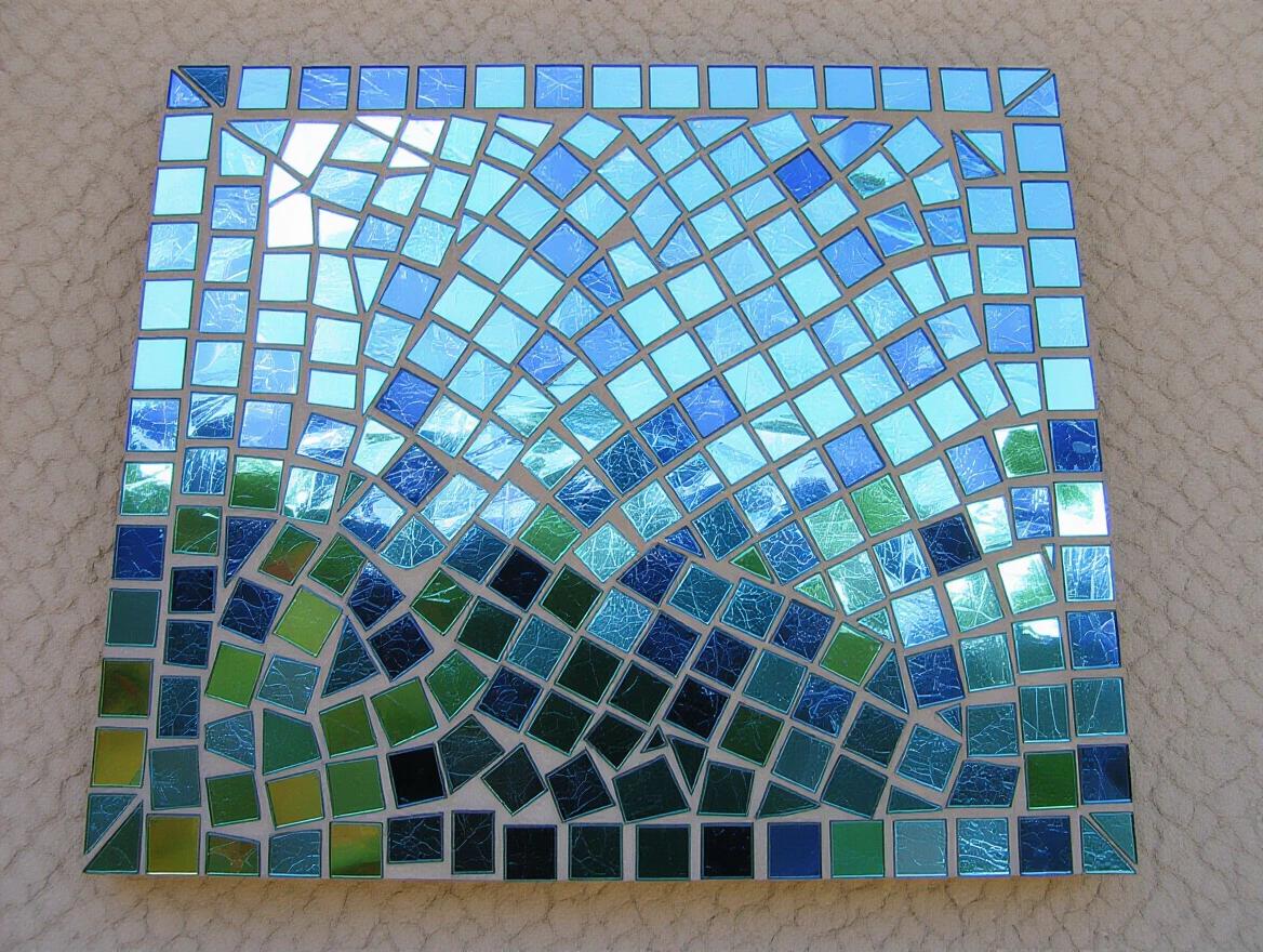 Iridescent ceramic tile and glass mosaic artwork. Ethereal and abstract in design. Features a colorful arrangement of tiles in a unique pattern.