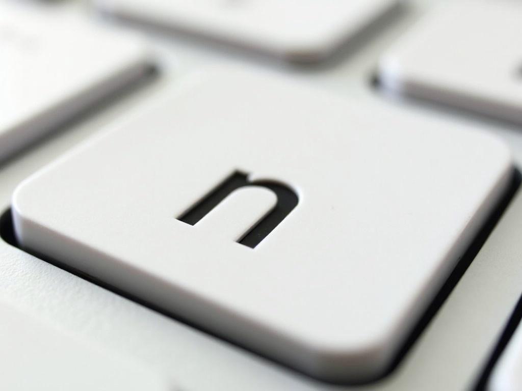 This image features a close-up view of a white keyboard key. The key is prominently displayed, showing the letter 'n' embossed in black. The design highlights the simplicity and functionality of modern keyboards. The lighting is bright, emphasizing the clean lines and textures of the key. It is an ideal imagery for technology-related topics and digital communication.