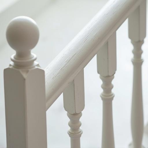 Close-up photograph of white wooden railing. Focus on wood texture. Show craftsmanship details. Photorealistic style.
