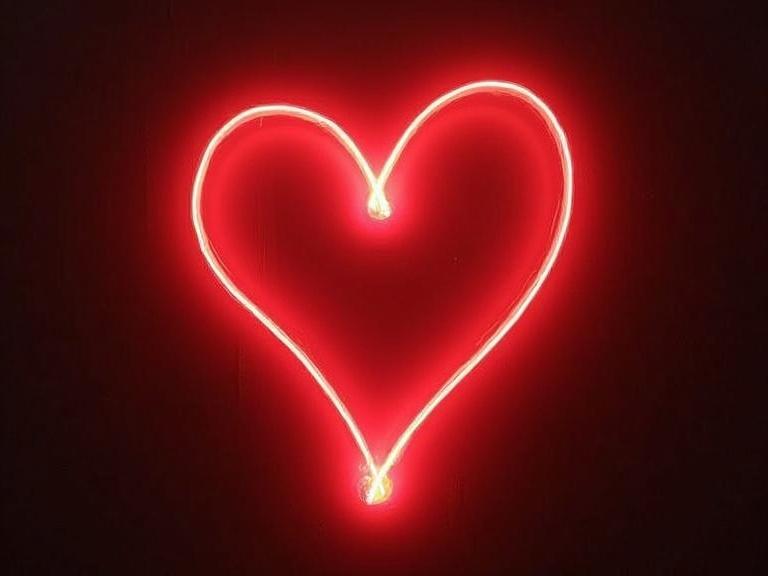 Light painting creating a glow effect in the shape of a heart. Deep red color stands out against a dark background. Illuminating design evokes romantic feelings.