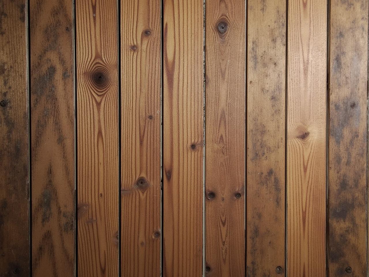 This image showcases a close-up view of wooden planks arranged vertically. The rich brown tones give a warm and rustic feel. The wood has various textures and patterns, highlighting the natural grain. Some planks appear smoother, while others have a weathered look. This versatile wood texture could be perfect for various design projects or as a backdrop.