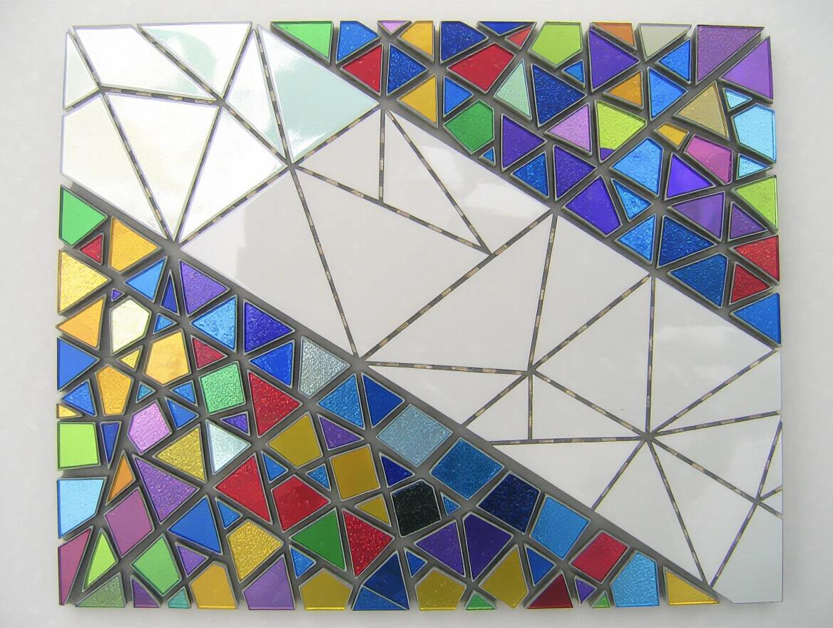 Iridescent ceramic tile and glass mosaic features abstract shapes in vibrant colors. The design emphasizes geometric patterns with diverse textures and finishes.