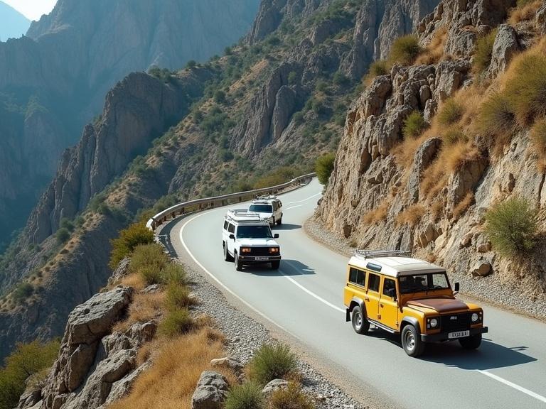 Real photo with modern-day vehicles including two 4x4s and one rusted old yellow cab. Shows a scenic winding mountain road surrounded by steep cliffs and rocky terrain. The vehicles are on a narrow road near a guardrail. Overall scene suggests remote and rural travel in nature.