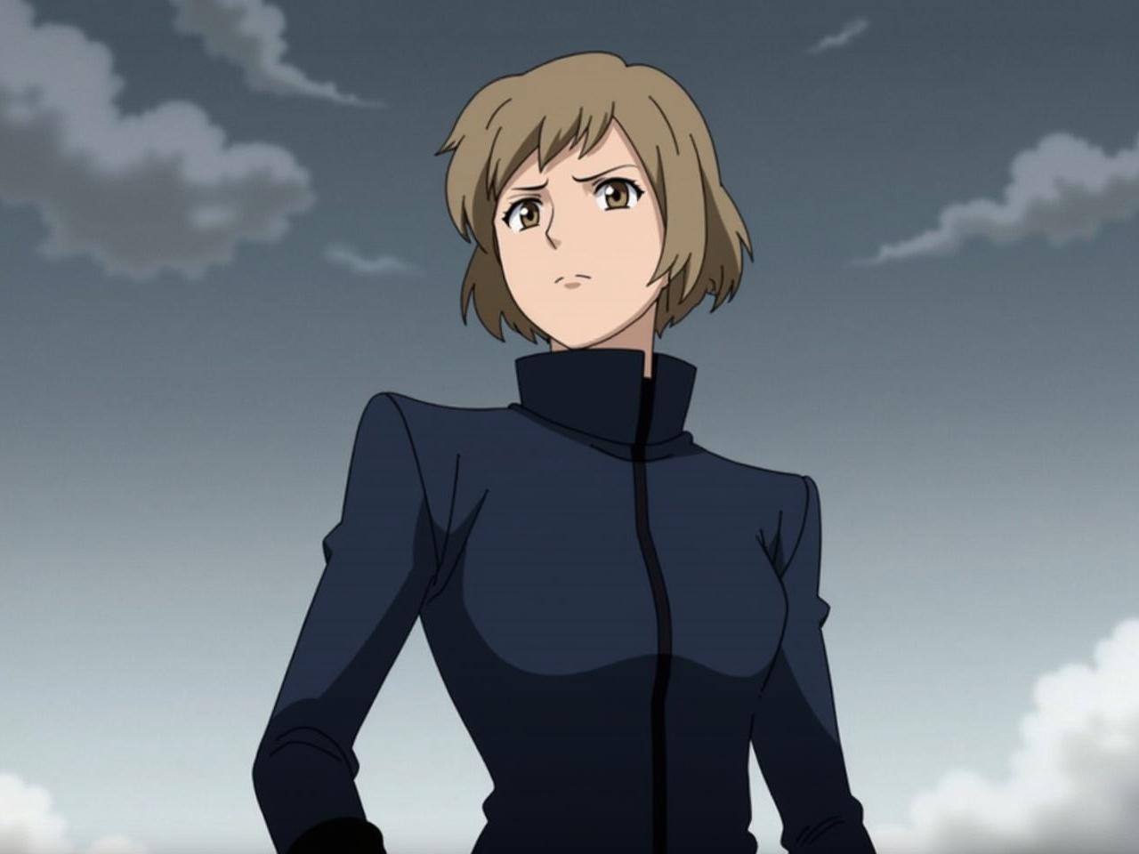 The image shows a character from an animated series, wearing a stylish dark blue jacket with a high collar. The background consists of a cloudy sky, which gives a dramatic effect to the scene. The character appears confident and determined, standing with a slight angle toward the viewer. The hair is a light brown color, styled in a neat, modern way. The focus of the image is on the character's posture and clothing, highlighting their role as a strong figure in the narrative.