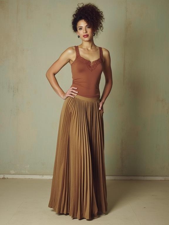 Model wears a pleated skirt and a lace-trimmed cami. The outfit displays a sophisticated style. The color palette consists of warm tan and brown hues. Soft lighting enhances the fashion details. The model poses confidently with one hand on her hip.