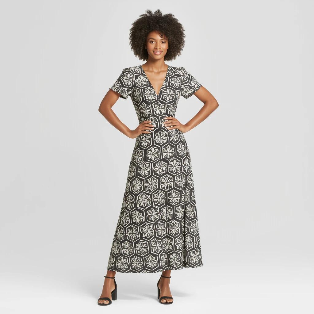 Modelo negro em pé usando um vestido longo com padrão.