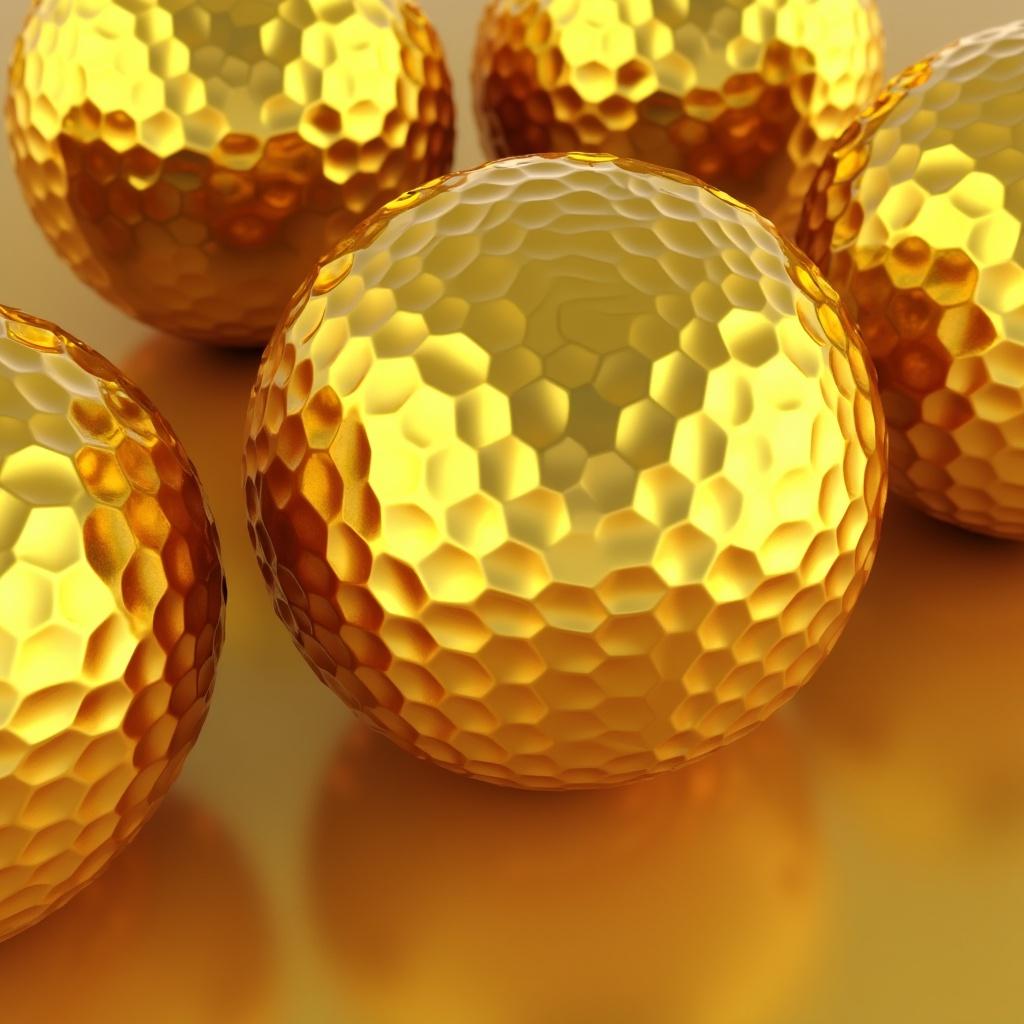 Several shiny golden geometric spheres with a polygonal surface pattern.