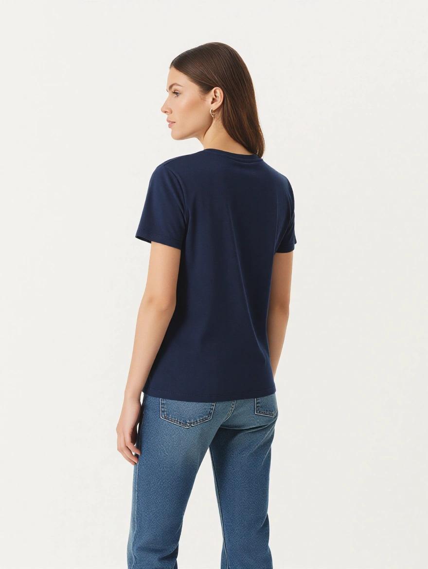 Photorealistic half body shot from the back female model wearing a crisp plain navy t-shirt. Natural professional pose standing straight relaxed shoulders. Isolated on a plain white background. Clean studio lighting. Urban clothing brand aesthetic. Ultra high resolution sharp details on fabric texture.
