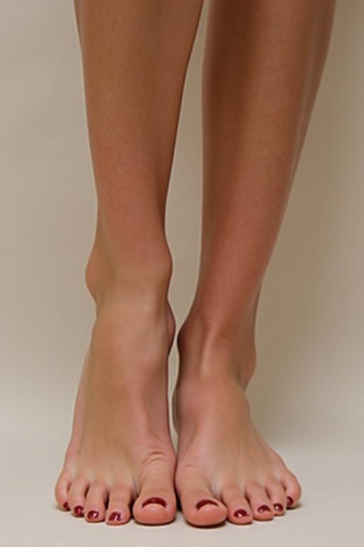Display feminine feet with well-groomed soles. Emphasize natural beauty and elegance. Soft lighting enhances features. Straight-on perspective shows feet detail.
