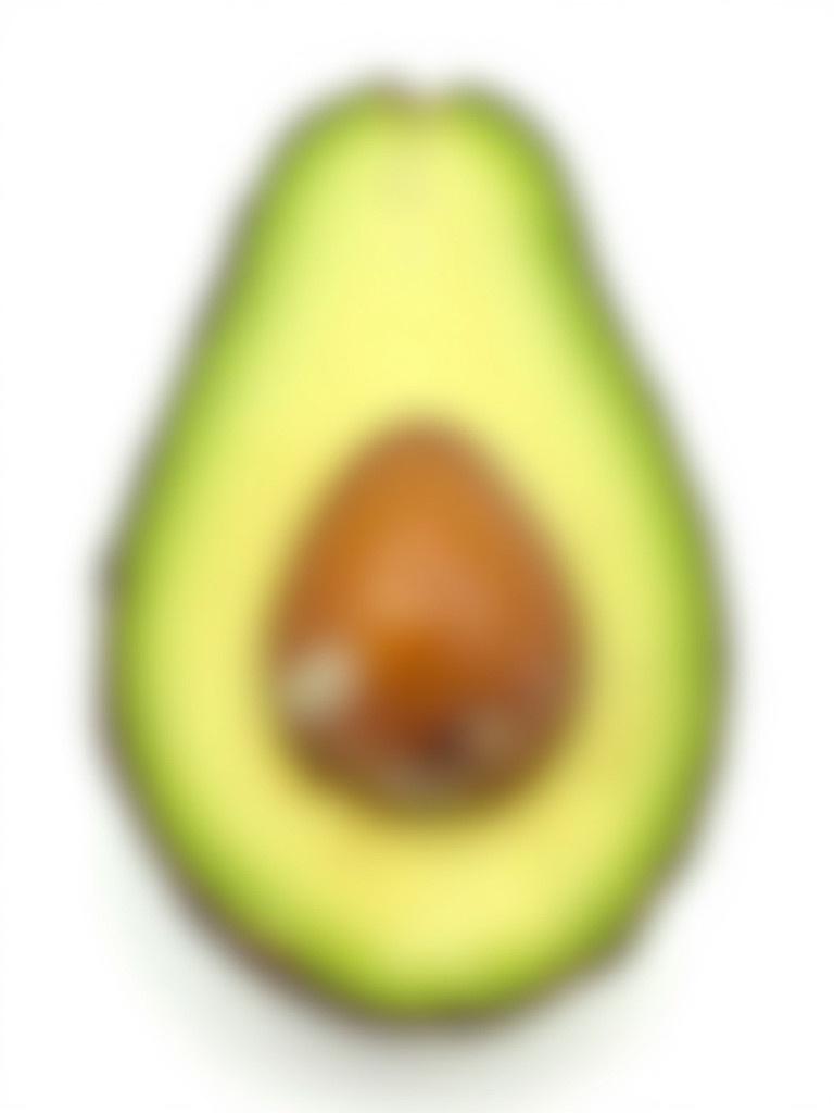 A ripe avocado half rests on a white background. The smooth green flesh surrounds a brown seed in the center. The outer skin is dark green and slightly textured. The creamy interior contrasts with the skin.