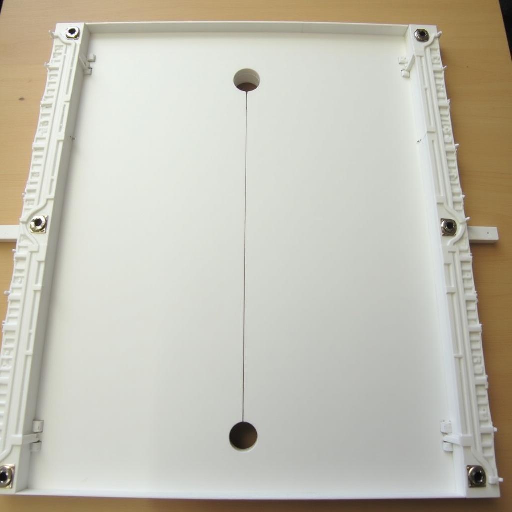 A plastic board with specific dimensions and features. The board thickness is 5mm, width is 8cm, and length is 40cm. Rails are present on the length sides, with a thickness of 3mm and a height of 2.5cm. A hole is located in the middle of the board. The hole is circular, 5mm in diameter, centered at 20cm from the width. A section is cut off for the hole to create a straight line facing the width side, with an arc. The longest distance from the middle of the straight part to the arc measures 4.5mm.