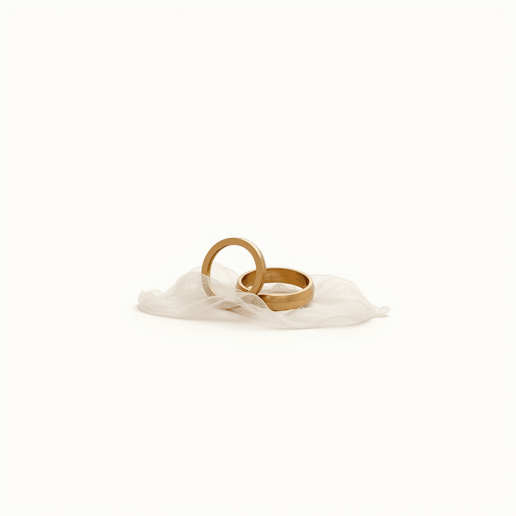 Two gold rings resting elegantly on a sheer white fabric.